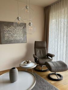 瓦尔内明德Apartments in Warnemuende的客厅配有椅子和桌子