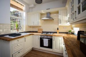 泰恩河畔纽卡斯尔West Beck House - Newcastle 2的厨房配有白色橱柜和炉灶烤箱。