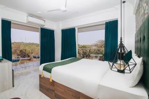 安君纳The Mayfield Resort, Vagator的一间卧室配有大床和绿色窗帘