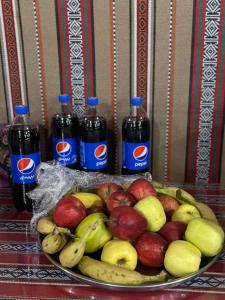 瓦迪拉姆Wadi Rum Magic Camp的一盘苹果和香蕉,两瓶苏打水