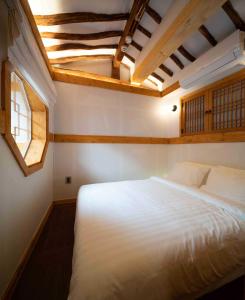 首尔Luxury hanok with private bathtub - SW02的卧室设有一张白色大床和天花板