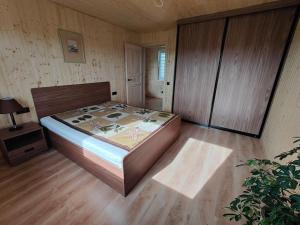 ŠtadviliaiModern family house by the lake in Zarasai的一间卧室配有一张床,铺有木地板