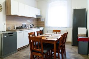 拉贝河畔乌斯季J&M Apartments的厨房配有木桌、椅子和水槽