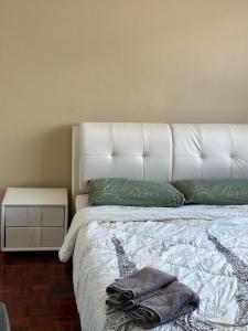 古晋赛拉达旅馆的一张带白色床头板和绿色枕头的床