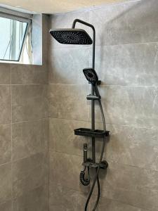 古晋赛拉达旅馆的浴室内配有带黑色淋浴架的淋浴
