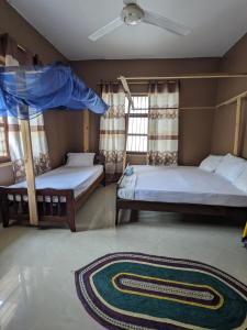 Stone TownFlamingo Guest House ZNZ的卧室配有两张双层床和地毯。
