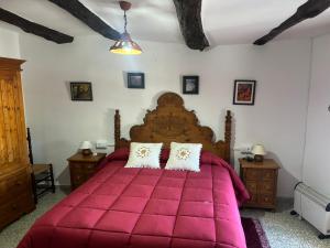 潘潘埃拉Casa Pepo的一间卧室配有一张红色大床和两个枕头