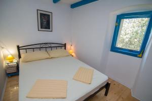 大洛希尼Ferienhaus mit Privatpool für 4 Personen ca 70 qm in Veli Lošinj, Kvarner Bucht Losinj的一间小卧室,配有白色的床和窗户