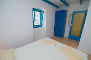 大洛希尼Ferienhaus mit Privatpool für 4 Personen ca 70 qm in Veli Lošinj, Kvarner Bucht Losinj的一间设有床铺和蓝色门的房间