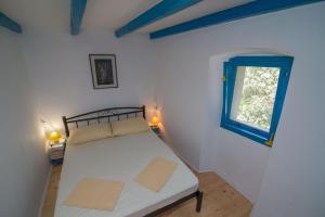 大洛希尼Ferienhaus mit Privatpool für 4 Personen ca 70 qm in Veli Lošinj, Kvarner Bucht Losinj的一间小卧室,配有床和窗户