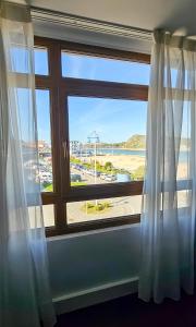 苏安塞斯苏安塞斯码头水疗酒店的配有窗帘的窗户,享有海滩美景