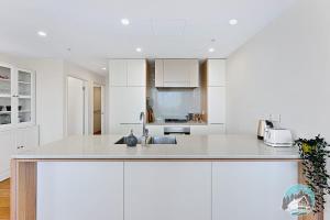 悉尼Aircabin｜Wentworth Point｜Stylish Comfy｜2 Beds Apt的白色的厨房配有白色橱柜和水槽