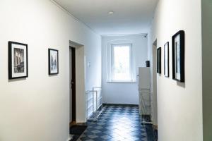 拉贝河畔乌斯季J&M Apartments的墙壁上挂有白色墙壁和图片的走廊