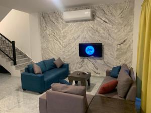 Al KafraynJimi Chalet的客厅配有沙发和石墙电视。