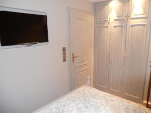 曼克玛肖Ferienwohnung für 2 Personen ca 55 qm in Munkmarsch, Nordfriesische Inseln Sylt - a87454的卧室配有一张壁挂式平面电视的床。