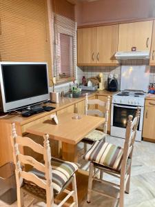 希俄斯Chios Cozy studio Island Getaway的厨房配有木桌、椅子和电视
