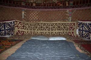 NurotaYurt Stay Family Khansar的圆顶帐篷内的一张大床,配有枕头