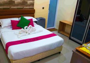 VeymandooVeyo Retreat的一间卧室配有红色和绿色枕头的床