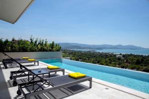 曾蒙海滩Sunset Estates - Samui Luxury Villas的一个带躺椅的游泳池,享有水景