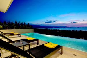 曾蒙海滩Sunset Estates - Samui Luxury Villas的游泳池旁的游泳池配有黄色软垫椅子