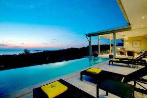 曾蒙海滩Sunset Estates - Samui Luxury Villas的黄昏时带游泳池的房子