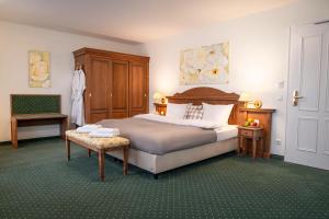 Lellichow勒里考沃兰德酒店的一间卧室配有一张大床和一把椅子
