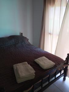 圣拉斐尔Estancia la juana的一张带两条毛巾的床和窗户