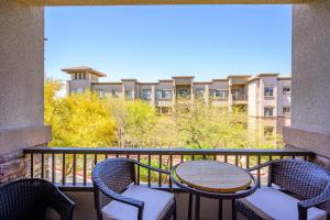 凤凰城Villa Desert Ridge condo的一个带桌椅的阳台和一座建筑