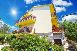 班约勒Ferienwohnung für 6 Personen ca 110 qm in Banjole, Istrien Istrische Riviera的带阳台的黄色和白色建筑