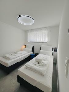纽伦堡Xzllenz - 4 Schlafzimmer, Zentral, Parken, U-Bahn, 2 Bäder, 4 Smart-TV, optional Einzelbett的白色的客房设有两张床和一盏灯。