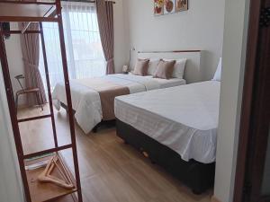 普禾加多44 Guest House Syariah的酒店客房设有两张床和梯子
