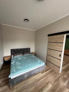 文戈热沃Apartament Zamkowa 14的一间卧室配有一张大床和一个木制梳妆台