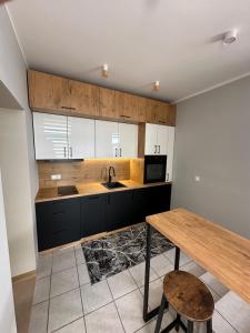 文戈热沃Apartament Zamkowa 14的厨房配有木桌和水槽。