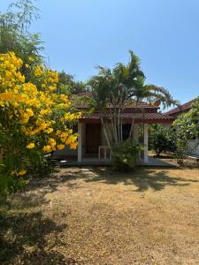 班拉克海滩苏梅岛花园度假酒店的前面有黄色花的房子
