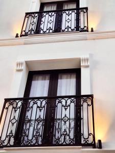 都拉斯Old Town Villa的白色建筑上带黑色栏杆的窗户