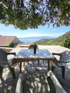 蒂瓦特Authentic Mediterranean House with Postcard Sea View的野餐桌,上面有一瓶葡萄酒