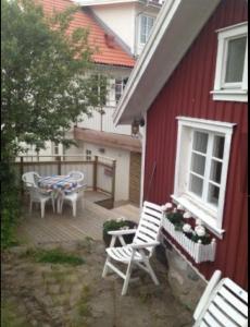 弗加尔巴卡Lillstuga Badholmen的红色的房子,配有带桌椅的甲板