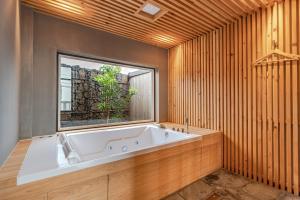 济州市Le Village Aewol G的窗户客房内的大浴缸