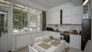 第比利斯Elegant 1BR Vake Apt for 3 - By Wehost的厨房配有白色橱柜和鲜花桌