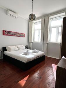 波尔图Covelo Apartment的一间卧室设有一张床和两个窗户。