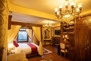 西姆拉Rajkamal-The Himalayan Heritage的一间卧室配有一张床和一个吊灯