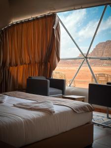 瓦迪拉姆RUM NEPTUNE lUXURY CAMP的一间带沙发床的卧室,享有沙漠美景