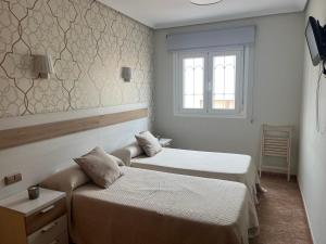 埃尔卡沃德加塔PENSION NAVAS的酒店客房设有两张床和窗户。