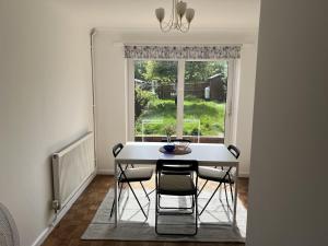 莱顿巴泽德Charming 3-Bed House in Leighton Buzzard的一间带桌椅和窗户的用餐室