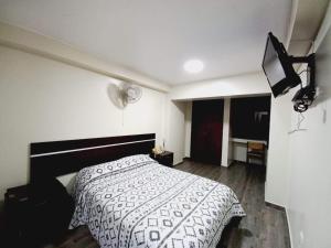 利马Hotel Perú Pacífico的一间卧室配有一张带黑白色棉被的床