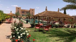 拉希迪耶Hotel Oasis Palace的一个带桌椅和游泳池的度假酒店
