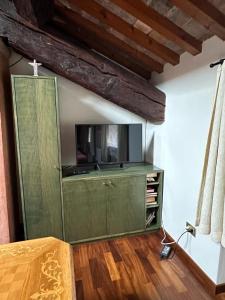 巴萨诺－德尔格拉帕Residenza Angela的一间房间内的绿色橱柜,配有电视