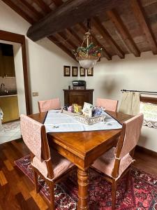 巴萨诺－德尔格拉帕Residenza Angela的一间带木桌和椅子的用餐室