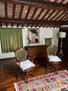 巴萨诺－德尔格拉帕Residenza Angela的客厅配有钢琴和两把椅子