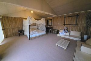 MarghamMargham Desert Safari Camp的坐在房间里床边的女人